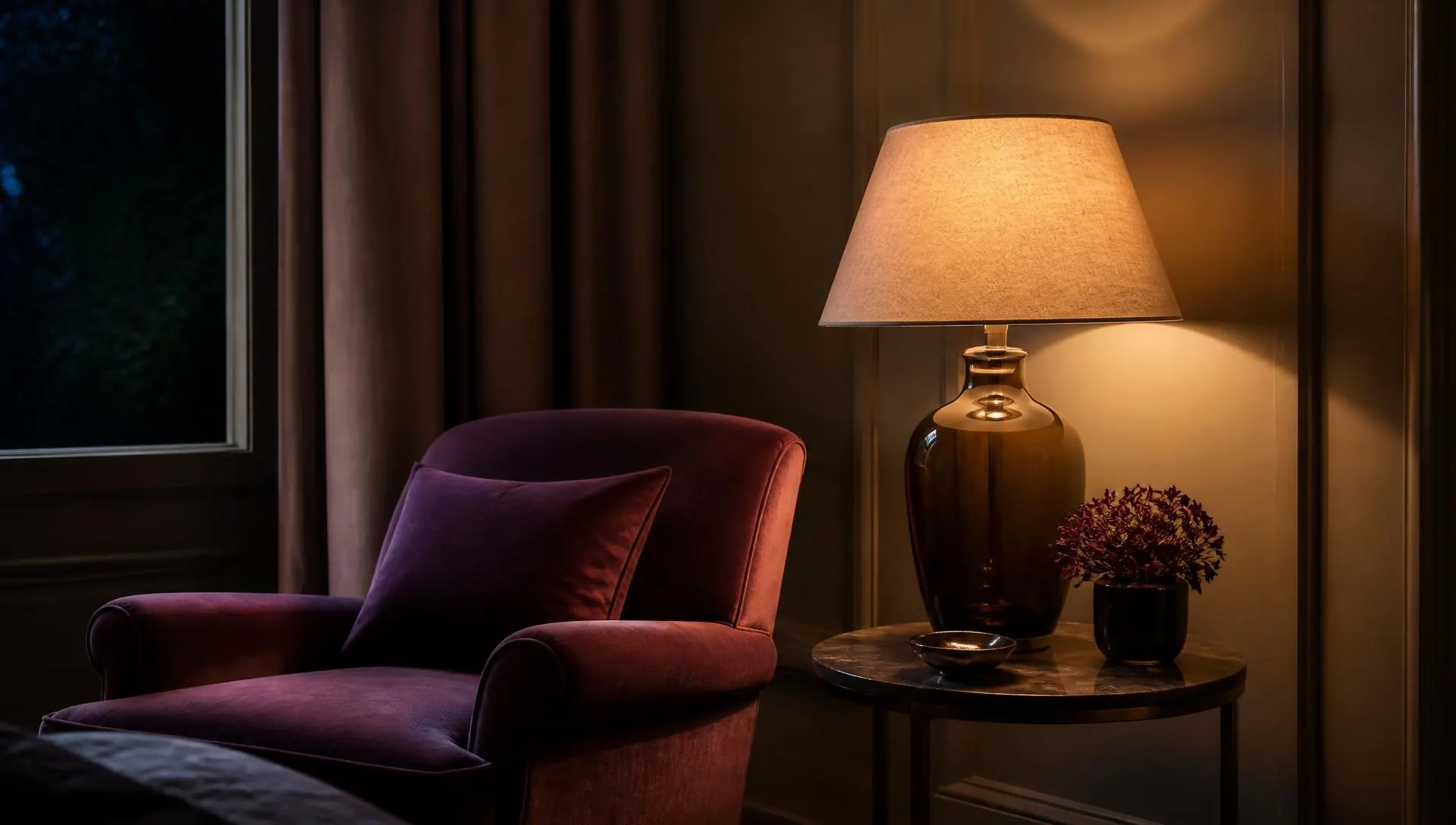 A lit lamp beside an armchair in a warm evening interior, postpartum anxiety therapy in Virginia